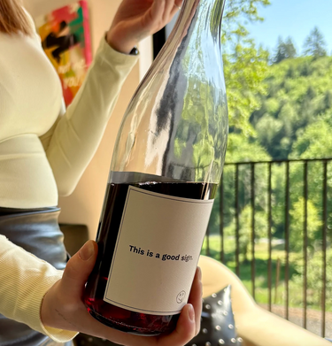 A wine host serving a bottle at Artist Block, a close up of the label of red wine.