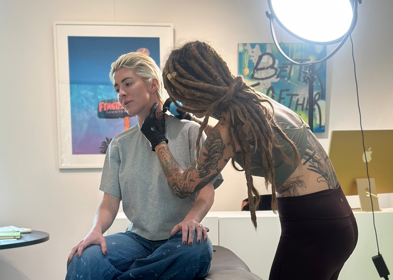Person receiving a tattoo from another person in a tasting room.
