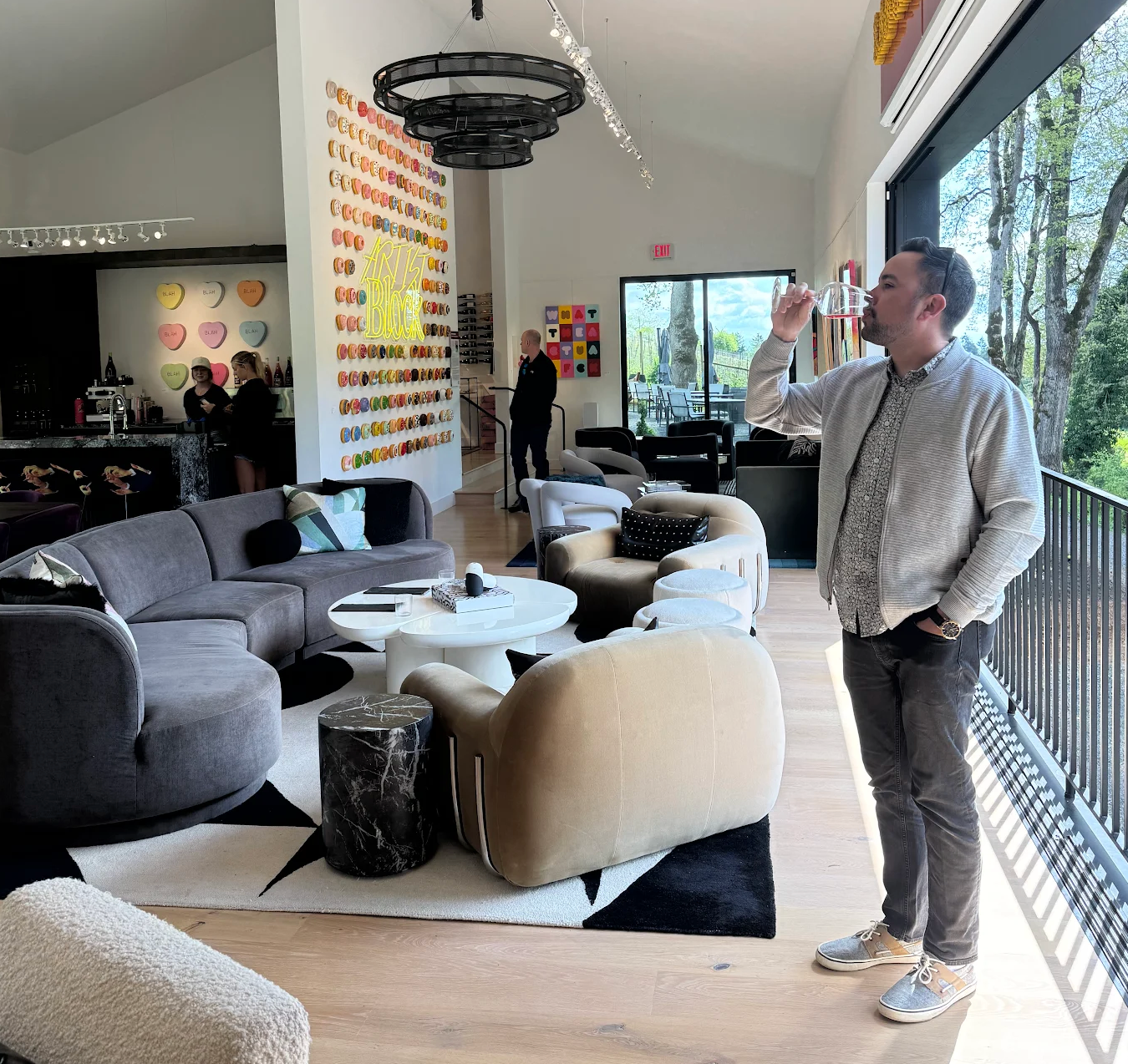 Man standing in a modern living room with stylish furniture and decor.